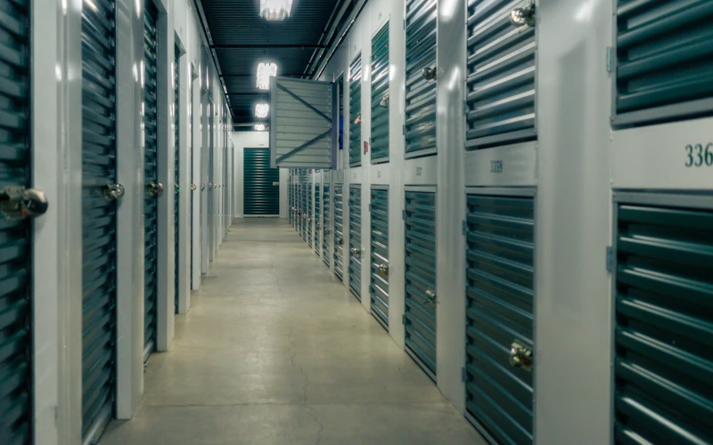 A hallway of green storage unit doors with padlocks